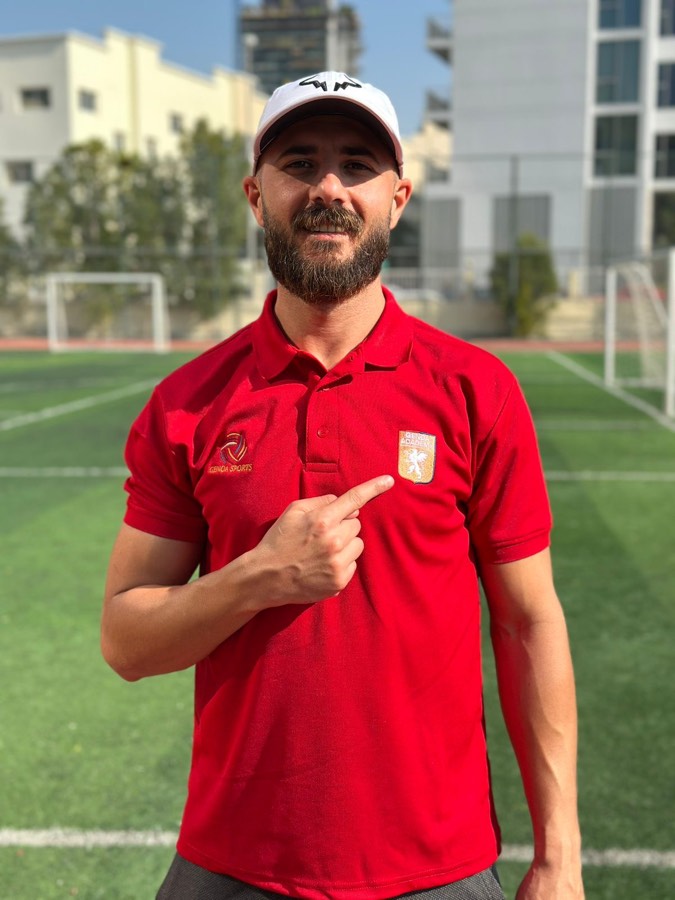 Genoa Academy coach in red polo and cap